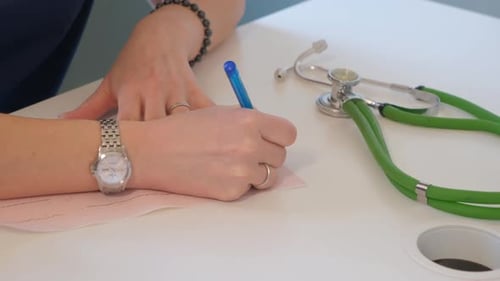 Medical Professional Writing on Paper at Clinic