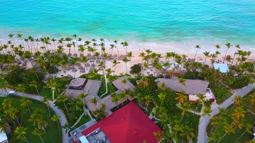 An aerial drone shot of the Dominican Republic shows the beachfront and the waves hitting the shorel