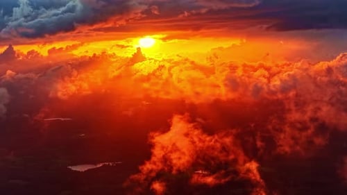 Fiery red orange sunlight pours through dramatic clouds during sunset, illuminating the sky with