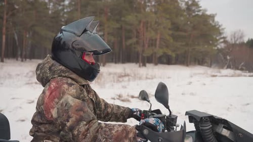 Winter ATV Adventure Snowy Forest Rider Checks Gear Rider in Snow Adjusts Helmet Mirror Carefully