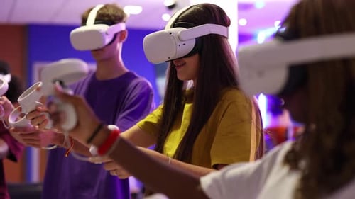 Group of young gamers wearing vr headsets and holding controllers are immersed in a virtual reality