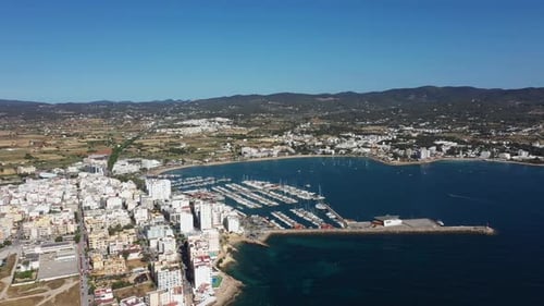 Aerial drone footage of a beach in the village of Sant Antoni on the island of Ibiza in Spain