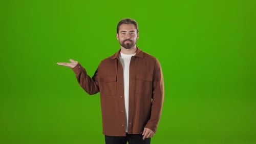 Confident Man Pointing to Copy Space on Palm in Studio