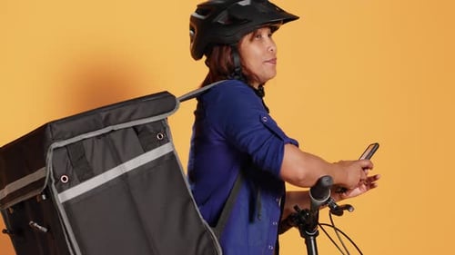 Delivery Worker Standing Next to Bike Holding Phone