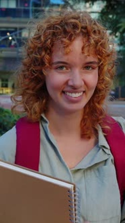 Vertical Video Portrait of Ginger Student Holding a Binder on University Campus