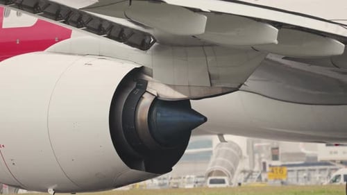 Detail des Triebwerks und der Tragfläche eines großen Passagierflugzeugs auf dem Rollfeld des Flughafens