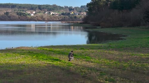 Male Photographer Taking Nature Photos Near The Lake - Aerial Drone Shot