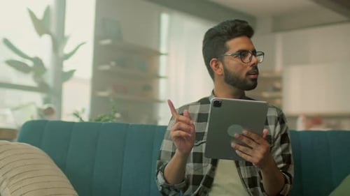 Young Adult Using Tablet on Couch Indoors