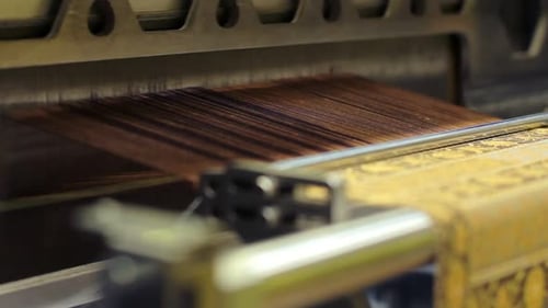 Looms weaving patterned cloth in textile factory