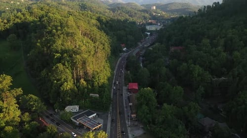 Vista aérea de aproximación a la ciudad de Gatlinburg, Tennessee, EE. UU., escapada por autopista y bosque a Great Smo