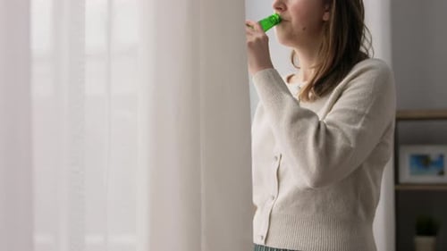 Woman Drinking Beer by Window at Home, Relaxing
