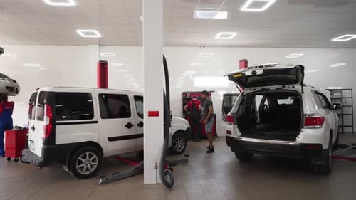 Auto Mechanics Work on Vehicles in Modern Car Service Garage Technicians Repair Cars Conduct