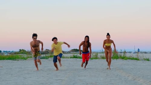 Young People Running Race On A Sandy Beach During The Summer - Slow Motion