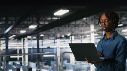 Data Center Computer Scientist Doing Maintenance Tasks on Laptop