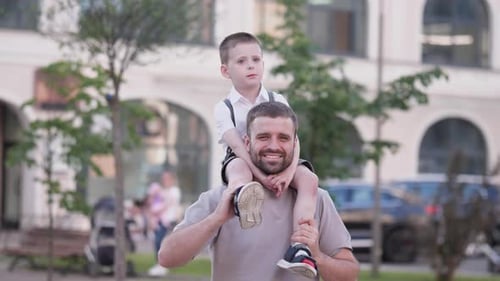 Happy Father and Son Portrait Against the Background of Modern City Buildings