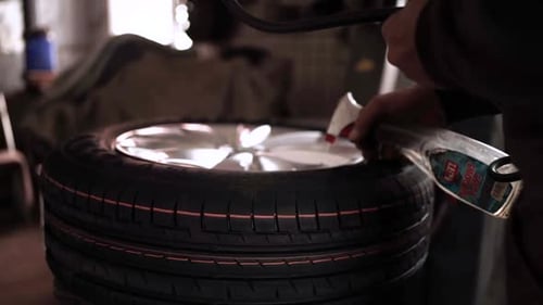 Man Sprays Tire at Indoor Garage