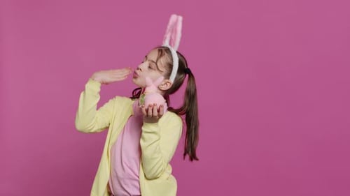 Jolly Schoolgirl Holding a Cute Rabbit Toy and Blowing Kisses in Studio