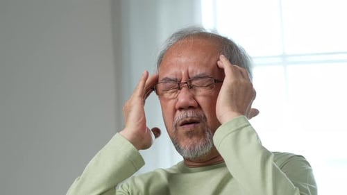 Man Massaging Temples Due to Headache Pain