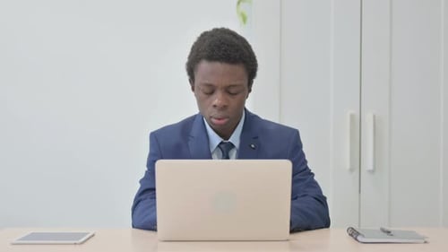 Young Adult Coughing While Working At Laptop