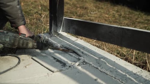 Builder Drills a hole in the wall with a Hammer Drill. Close-up of hammer drill perforator making ho