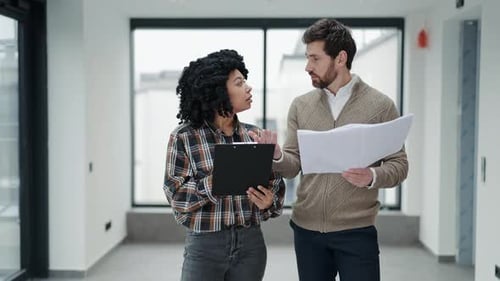 Business Colleagues Discussing Blueprints in a New Office Space