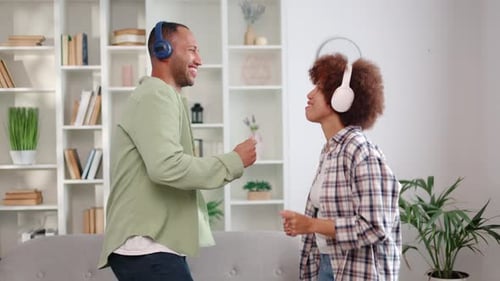 Couple Wearing Headphones Dancing Together at Home