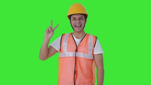 Happy Indian construction labour showing victory sign Green screen