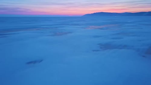 The Surface of the Frozen Lake Baikal at Sunset Drone Flying Low Above the Surface Beautiful Sunset
