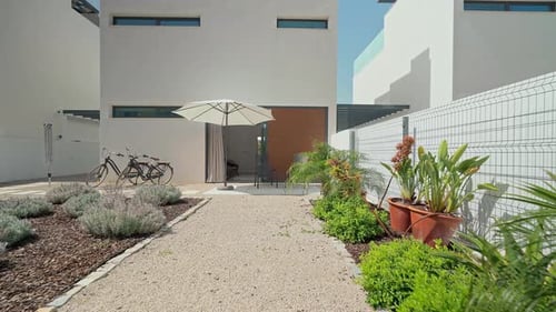Potted Plants Gravel Path and Comfortable Patio Furniture Create a Relaxing Atmosphere in a Modern