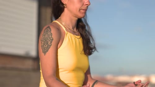 Woman Meditating Outdoors in Bright Yellow Outfit