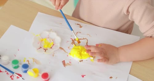 Child Paints a Craft Item at a Table