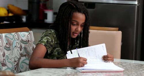 Teen Girl Doing Homework at Kitchen Table