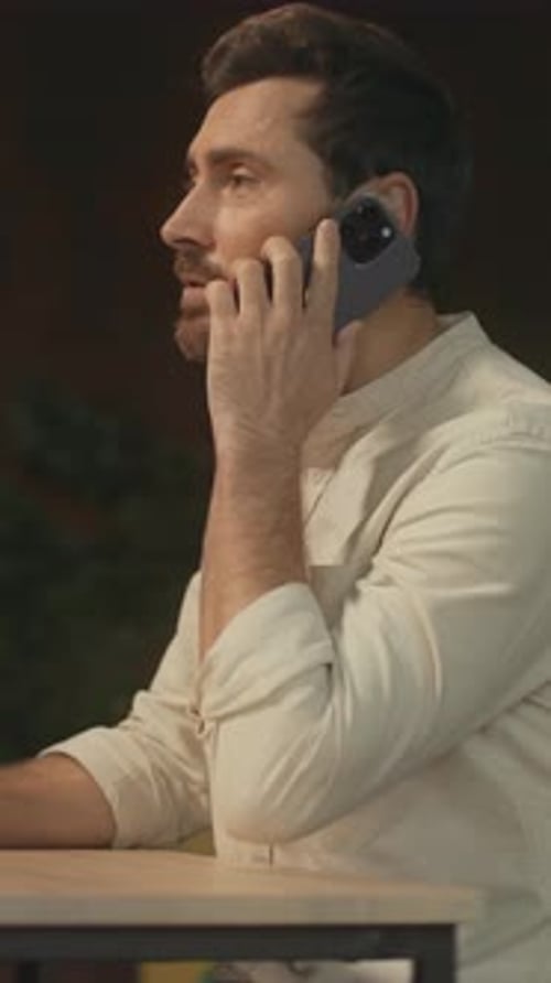 Bearded Man Talking on Phone at Office Desk