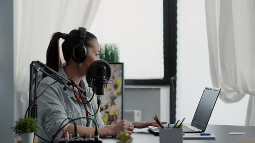 Woman Podcasting at Desk in Brightly Lit Room