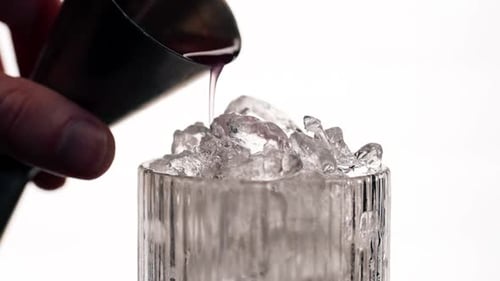 Makrorahmen eines Weinglases auf gewichtetem Hintergrund mit grob zerstoßenem Eis im Glas, Durstkühlung