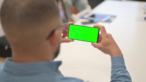 Hispanic Man Holding Phone Horizontal with Green Screen