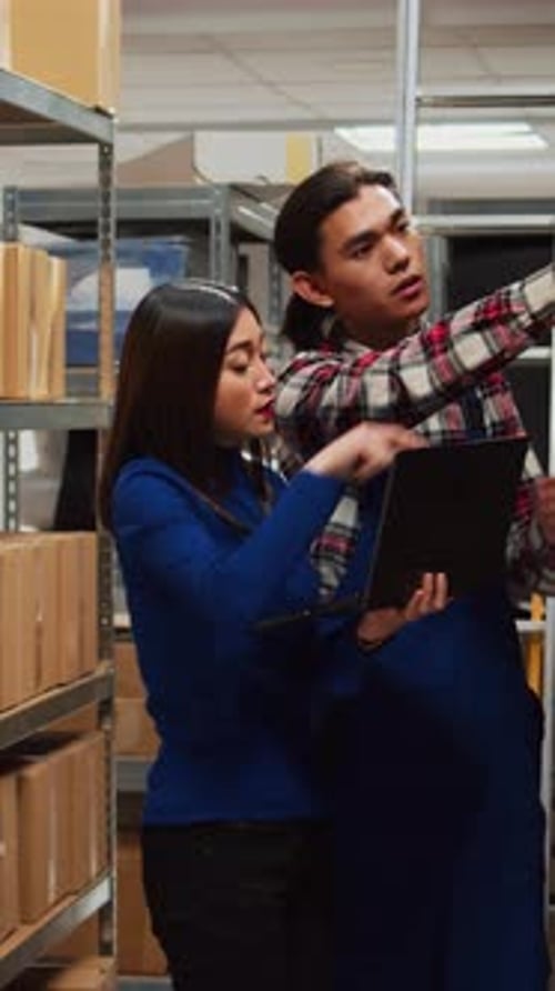 Warehouse Employees Use Laptop for Inventory Management
