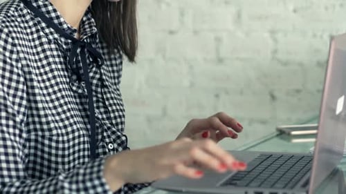 Young Woman Works on Laptop, Takes a Break