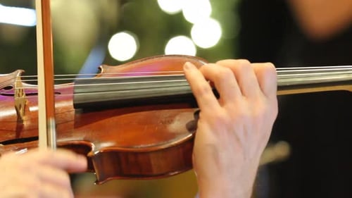 Violin being played with symphony during the holidays
