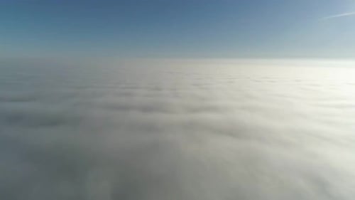 Flight over misty clouds in morning sunlight with little glory and city scape under clouds
