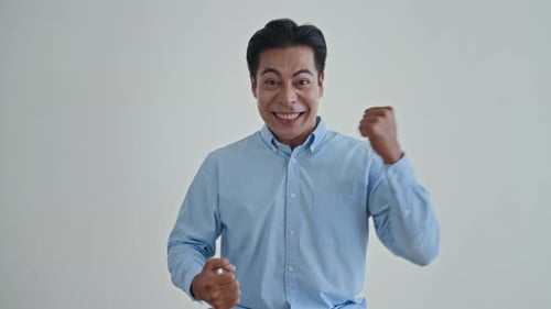 Man Celebrates with Clenched Fists in Studio