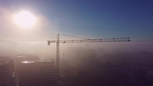 Tower Cranes on a Construcion Site with Dense Fog Aerial View