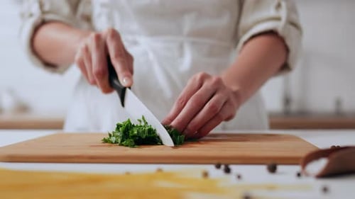 A Young Chef Cuts Greens With A White Ceramic Knife Cooking In Restaurant Fast Cooking Salad Cutting