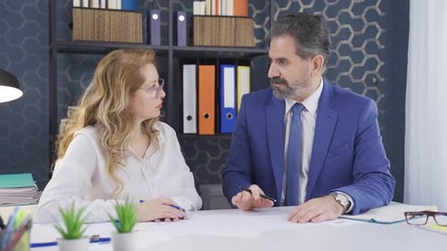 Female and male office worker. He is working as a team in the office.