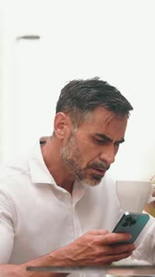 Mature businessman uses mobile phone sits on