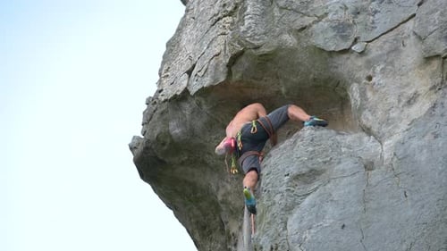 Determined Climber Clambering Up Steep Wall of Rocky Mountain Sportsman Overcoming Difficult Route