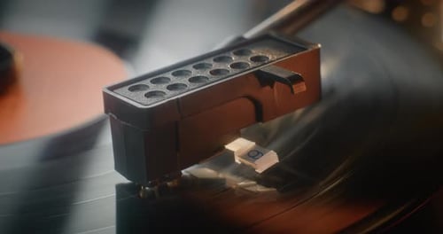 Macro Close Up of Needle Gently Scratching Grooves Playing Song On Vintage Turntable
