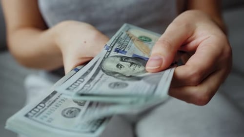 Woman Counting One Hundred Dollar Bills Close Up