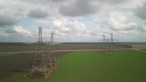 Aerial View of Power Lines Over Green Agricultural Field