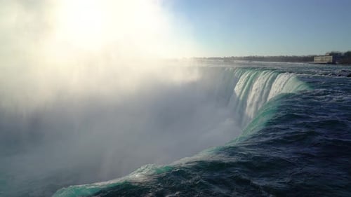 4k Niagara Falls water flowing into gorge at sunrise with birds flying through mist